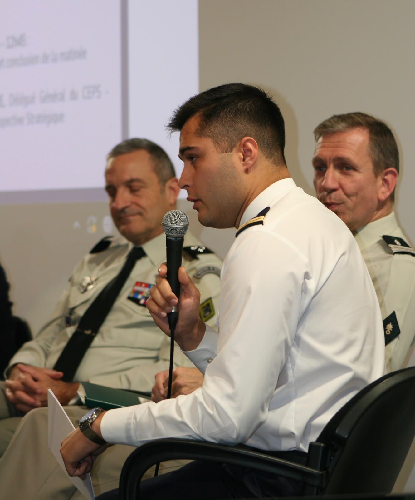 Un jeune officier de marine prend la parole lors d'une table ronde