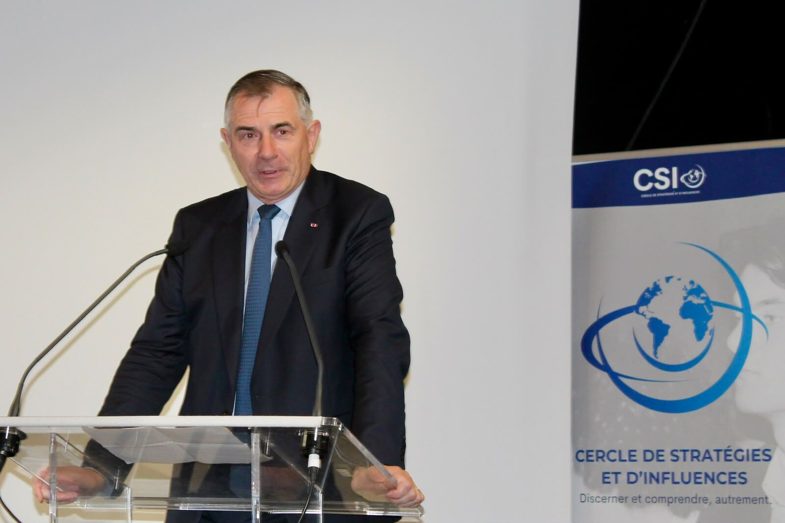 Un intervenant à la tribune devant la bannière du CSI